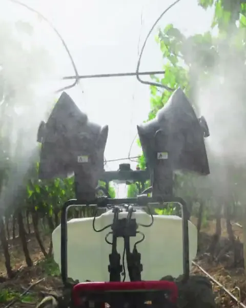 Robot terrestre pulverizando entre hileras de frutales